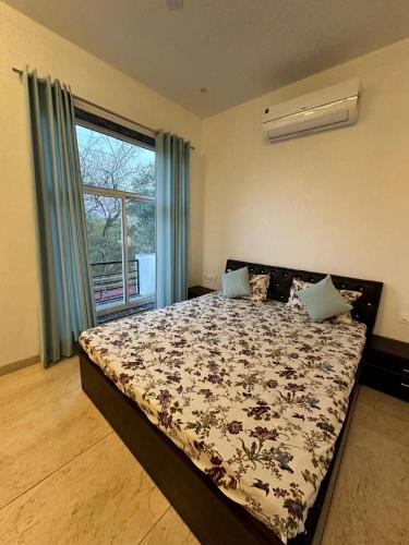 a bedroom with a bed and a window at namastay farm in Jaipur