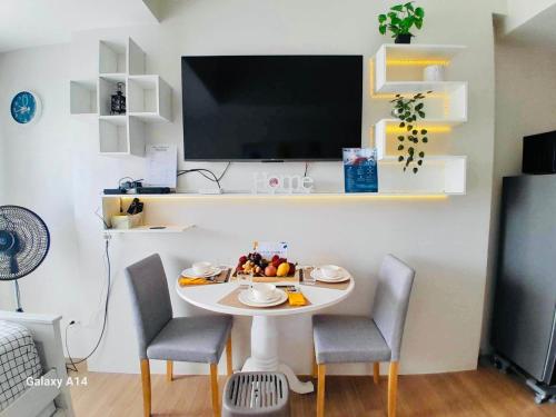 卡加延德奧羅的住宿－S&S Condostay，小桌子,椅子,墙上的电视