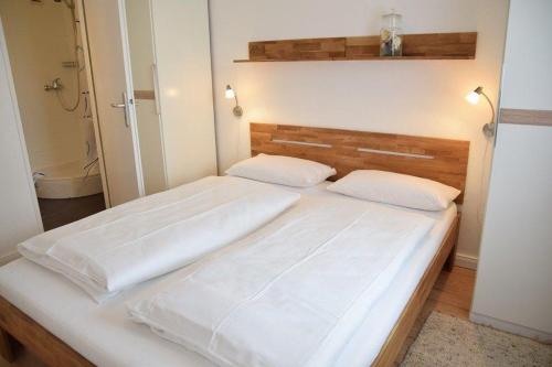 ein Schlafzimmer mit einem großen Bett mit weißer Bettwäsche in der Unterkunft Die 2 Zimmerwohnung mit Balkon liegt in der 1 Etage und ist ideal für 2 bis 3 Personen in Westerland