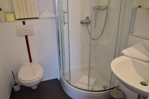 y baño con ducha, aseo y lavamanos. en Die 2 Zimmerwohnung mit Balkon liegt in der 1 Etage und ist ideal für 2 bis 3 Personen, en Westerland