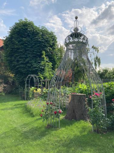 a metal cage with flowers in a garden at BIO Kastanienhof Erfurt - Appartements und ayurvedische Jurten in Erfurt