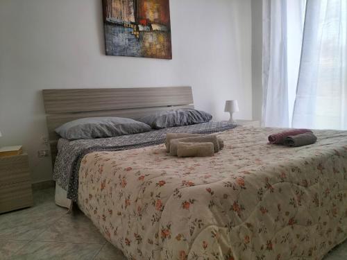 - une chambre dotée d'un grand lit avec un couvre-lit floral dans l'établissement la Massonica, à Pachino