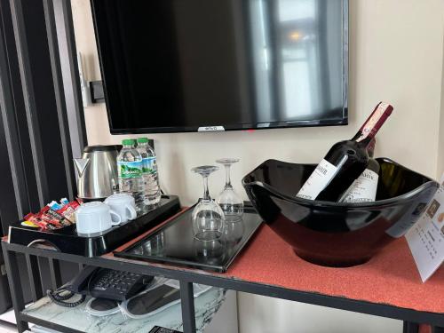 a table with a bottle of wine on a television at The Queen Airport Hotel in Arnavutköy