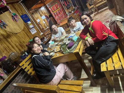 a group of people sitting at a table in a restaurant at Hoa Chanh Eco Home in Sa Pa