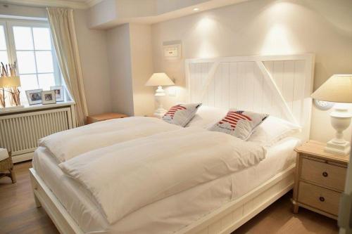 ヴェニングシュテットにあるOsterweg 53d, DHHの窓付きの客室で、白い大型ベッド1台が備わります。