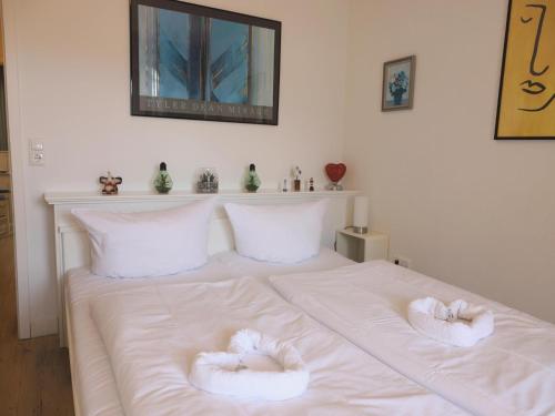 Una cama blanca con dos toallas. en Appartement mit 2 Balkonen, en Westerland