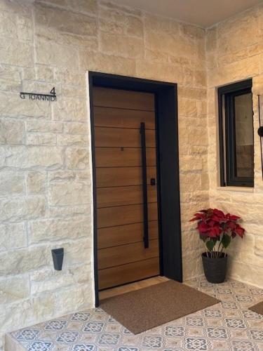 a front door of a house with a potted plant at Estia Luxury Apartment in Ierápetra