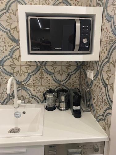 a microwave above a kitchen counter with a sink at Estia Luxury Apartment in Ierápetra