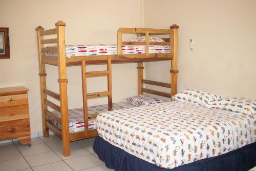1 dormitorio con 2 literas y 1 cama en Rancho de Playa Angie's Resort en San Luis La Herradura