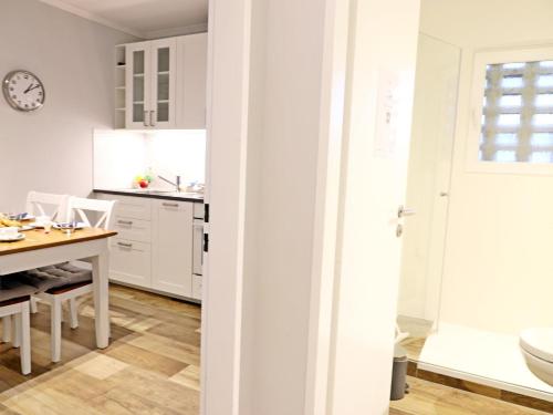 een keuken en eetkamer met witte kasten en een tafel bij -Zimmer-Appartement über 2 Etagen in Wenningstedt in ruhiger Lage in Wenningstedt
