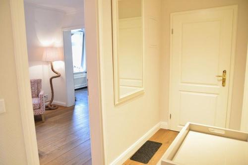 Habitación con puerta blanca y espejo. en Bundiswung 9 Whg. 4, GB2, en Westerland
