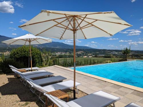 un grupo de sillas y una sombrilla junto a la piscina en Poggio 3 Lune, en Rignano sullʼArno