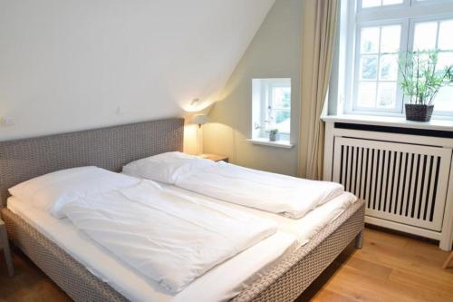 ein unmaskiertes Bett in einem Zimmer mit Fenster in der Unterkunft Bundiswung 7, Whg.2, GB7 in Westerland