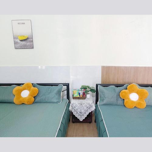 two beds with flowers on them in a room at Pra-Ha Villa in Tam Ðảo