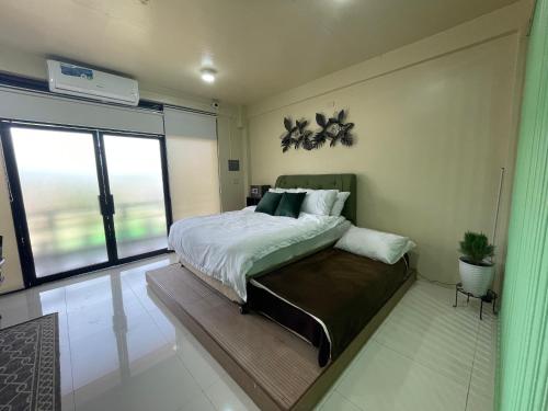 a bedroom with a bed and a large window at Lina Suites Premium Room in Malaybalay
