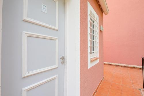 une porte vers une maison rose et blanche dans l'établissement Résidence le Hameau de Cap Esterel - maeva Home - Studio 4 Personnes - Sélection MAE-1064, à Saint-Raphaël