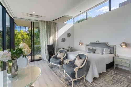 a bedroom with a bed and two chairs and a table at Omana in Rocky Bay