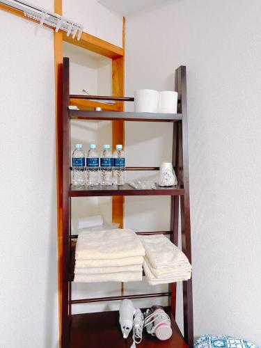 a shelf with bottles of water and towels at ひまわりHotel in Nagasaki
