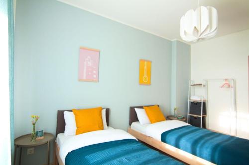 twee bedden in een kamer met blauwe muren bij Nice Apartment in Magdeburg in Maagdenburg
