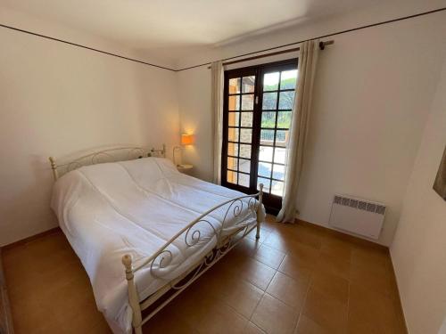 a bedroom with a white bed and a window at Villa in Vidauban with Pool and BBQ in Vidauban