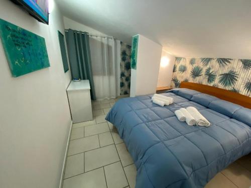 Un dormitorio con una cama azul con toallas. en Confort home, en Rende