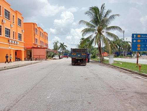 a truck driving down a street with a palm tree at HOTEL SAHARA INN TANJUNG MALIM in Kampong Chabang