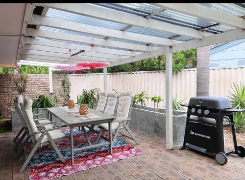 Un patio con parrilla y mesa y sillas. en Edgewater Whole Holiday Resort, en Perth