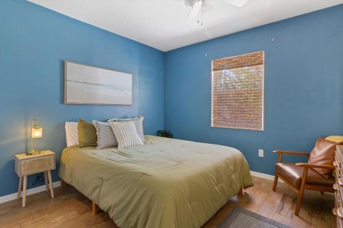 - une chambre bleue avec un lit et une chaise dans l'établissement Sebastian Home, 10 min from beach, à Sebastian