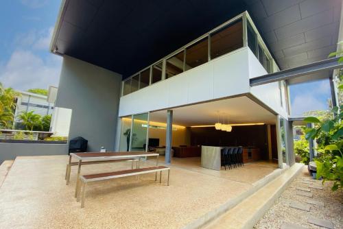 a modern house with a bench on a patio at Dune Ten by Kingscliff Accommodation in Fingal Head