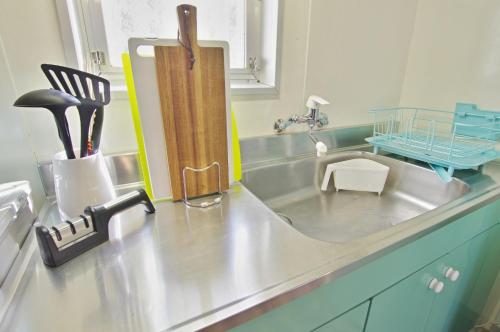 a kitchen counter with a sink with a kitchen utensils at VILLENT Atagawa Terrace - Vacation STAY 28115v in Okawa