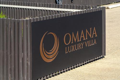 a black fence with a sign that reads omana luxury villa at Omana in Rocky Bay