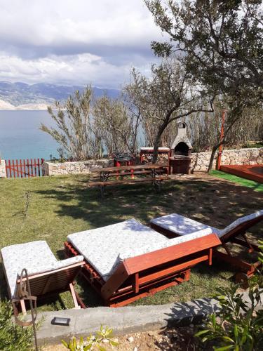 a picnic area with a table and benches and the ocean at Villa PANORAMA in Pag