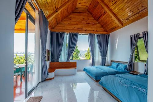 a bedroom with blue beds and a wooden ceiling at Điểm du lịch canh nông Avocado Farm in Lac Nghĩa