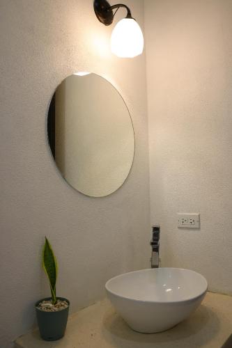a bathroom with a white sink and a mirror at Vista Verde Surf & Studios - jungle View in Carmen