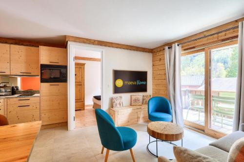 un salon avec des chaises bleues et une table dans l'établissement Résidence La Ginabelle - maeva Home - Appartement 3 pièces 6 personnes - Prestige MAE-7151, à Chamonix-Mont-Blanc