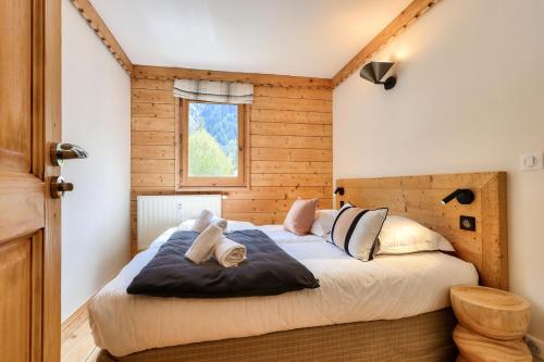 une chambre avec un grand lit dans une pièce dans l'établissement Résidence La Ginabelle - maeva Home - Appartement 3 pièces 6 personnes - Prestige MAE-7151, à Chamonix-Mont-Blanc