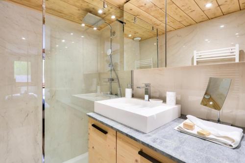 une salle de bain avec un lavabo blanc et une douche dans l'établissement Résidence La Ginabelle - maeva Home - Appartement 3 pièces 6 personnes - Prestige MAE-7151, à Chamonix-Mont-Blanc