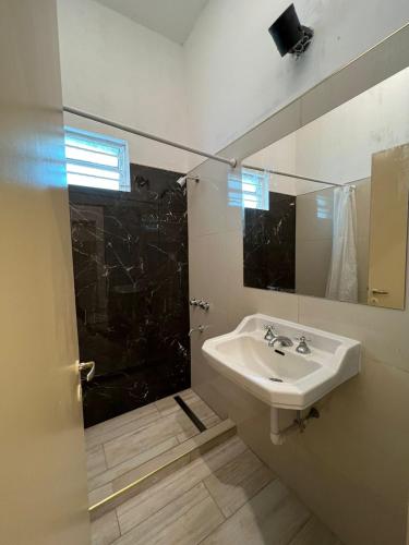 La salle de bains est pourvue d'un lavabo et d'une douche avec un miroir. dans l'établissement Casa Termal, completa, à Termas de Río Hondo