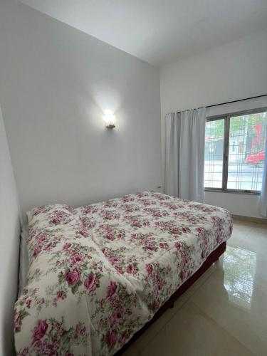 1 dormitorio con 1 cama con colcha de flores en Casa Termal, completa en Termas de Río Hondo