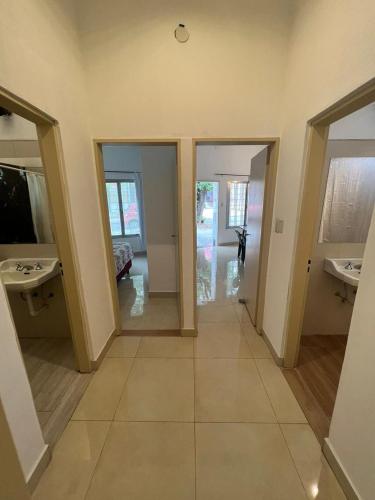 Habitación con 2 lavabos y pasillo con espejos en Casa Termal, completa en Termas de Río Hondo