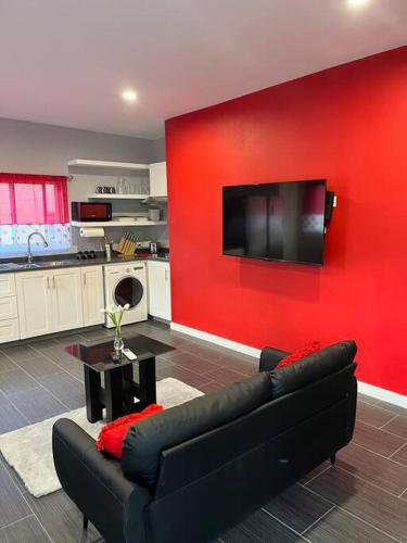 sala de estar con sofá y pared roja en Coconut Creek - Entire Two Bedroom Unit. en Hyde Park