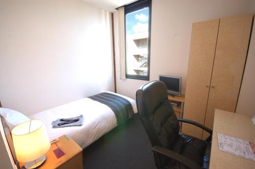 Cette chambre comprend un lit, un bureau et une fenêtre. dans l'établissement ArC LIFESTYLE SPACE & HOTEL, à Mito