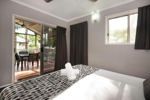 a bedroom with a bed and a dining room at Marlin Cove Holiday Resort in Trinity Beach