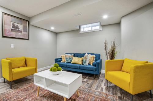 a living room with two blue and yellow chairs and a table at Newly renovated 2 bedroom basement suite in Calgary