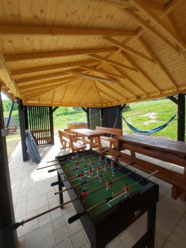 un tavolo da ping pong in un padiglione con panchine di Domki pod Bukowym lasem a Wańkowa