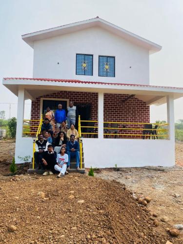 a group of people sitting on the porch of a house at WASNIK VILLA , PLOT 16/17/18, NF-7, NEEL FARM RESORT in Nagpur