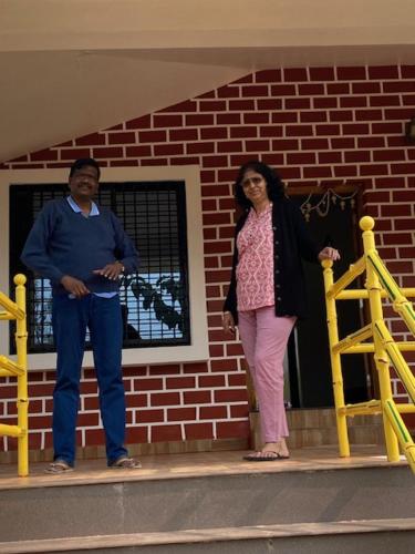 a man and a woman standing in front of a brick building at WASNIK VILLA , PLOT 16/17/18, NF-7, NEEL FARM RESORT in Nagpur