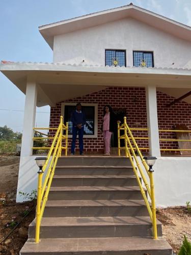 two people standing on the stairs of a house at WASNIK VILLA , PLOT 16/17/18, NF-7, NEEL FARM RESORT in Nagpur