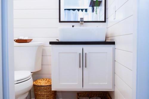 a bathroom with a white sink and a toilet at Somewhere in Texas Container Home in Alpine