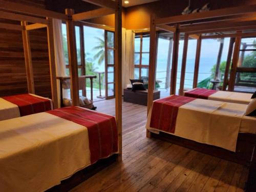 twee bedden in een kamer met uitzicht op de oceaan bij Mansud Shores Beach Resort - Talikud Island in Davao City